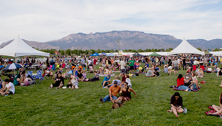 Families picnic in a park while listening to local music.